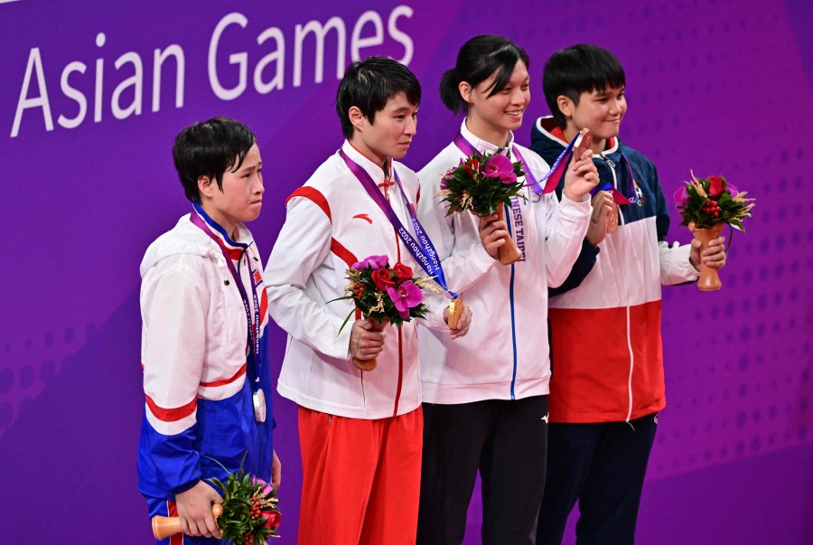 Gold medalist Yang Wenlu of China (second from left), silver medalist Won Ungyong of North Korea (left), bronze medalists Wu Shihyi of Taiwan (second from right) and Thananya Somnuek of Thailand pose for a photograph during the award ceremony for women's 57-60Kg final boxing match during the 2022 Asian Games in Hangzhou, China. -AFP/Ishara S. KODIKARA