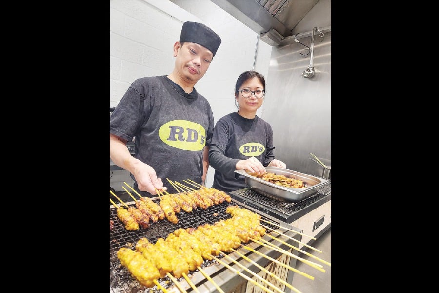 The couple preparing satay at their new outlet in Bicester Business Park in Oxford. PIX BY ZAHARAH OTHMAN