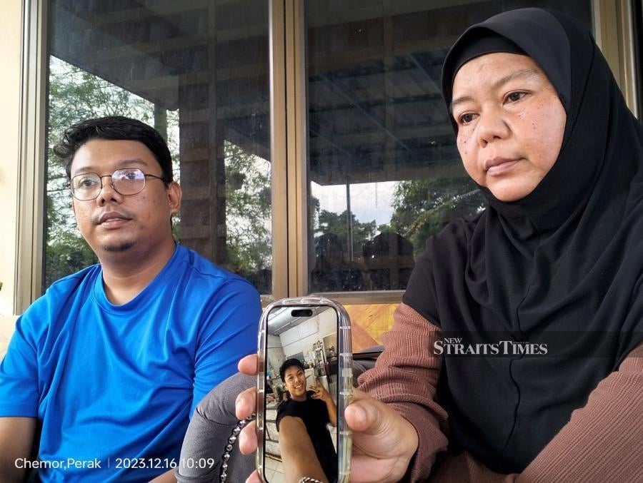 Muhammad Zaharif Affendi (pic in phone) is on his way home to Chemor from his school, SMK Jati in Meru, at 12.30 noon when he is embroiled in an encounter with police officer Mohd Nazri Abdul Razak. - NSTP/MUHAMMAD ZULSYAMINI SUFIAN SURI