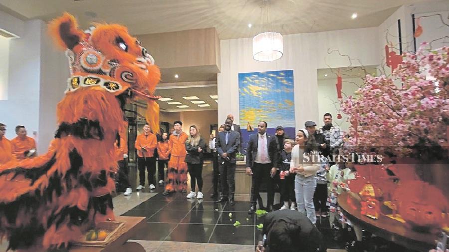 Patrons and workers at the Chelsea Harbour Hotel lobby enjoying a lion dance ushering in the Year of the Rabbit, on Friday night. -NSTP/ZAHARAH OTHMAN