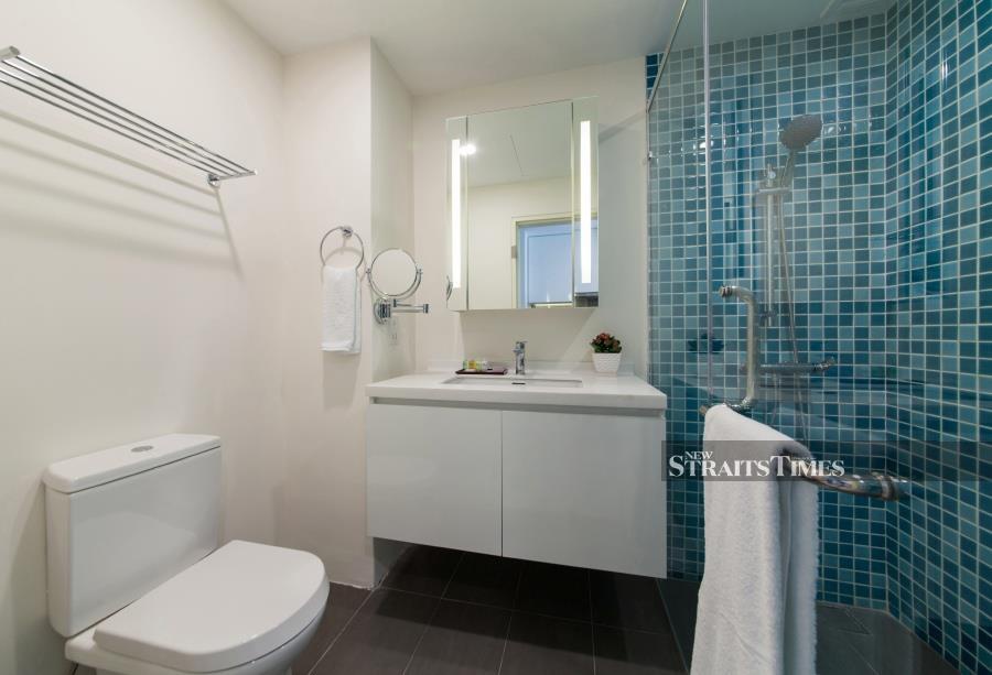 The ocean-fresh blue tiles give the bathroom a vibrant mood