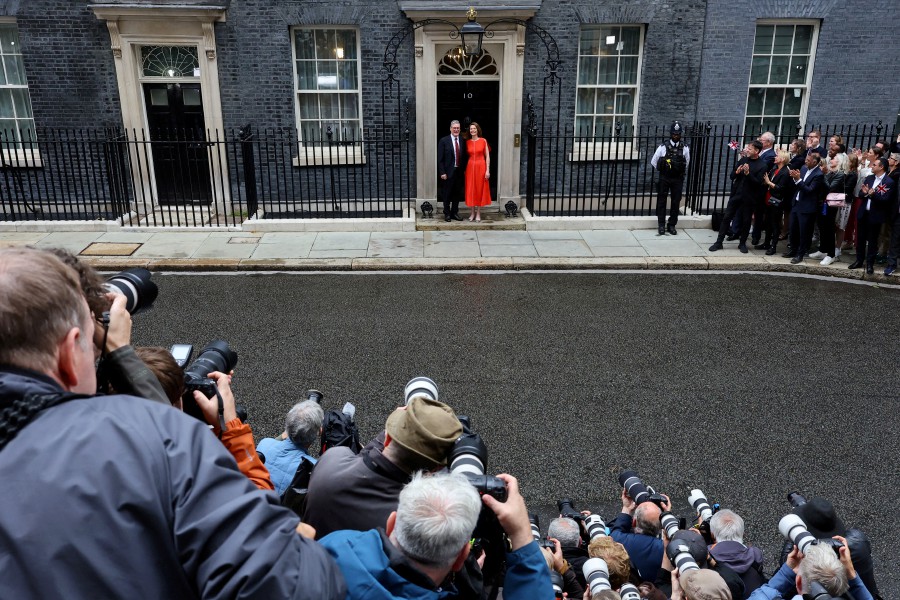 Photographers take pictures as British Prime Minister Keir Starmer and his wife Victoria Starmer stand outside Number 10 Downing Street, following the results of the election, in London, Britain, July 5, 2024. -- REUTERS