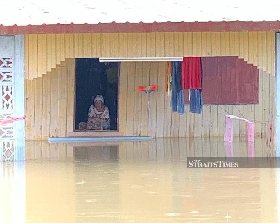 Zainab Hussin sits at her home despite the flood situation in Kampung Lubok Gong. - NSTP/Sharifah Mahsinah Abdullah