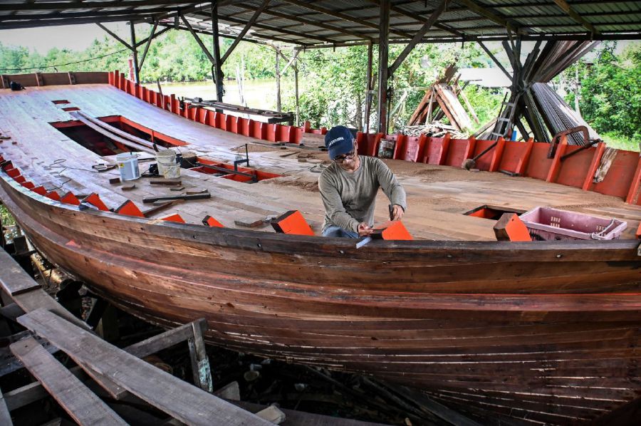 KUALA TERENGGANU, 10 JULY 2023 - Traditional boat builder Yusof Nawi, 52, working on a boat when met in Kampung Seberang Tumbuh here. Despite the advances in the boat building industry in the state with the use of modern technology, some builders chose to retain the use of the traditional method. -BERNAMA Pic