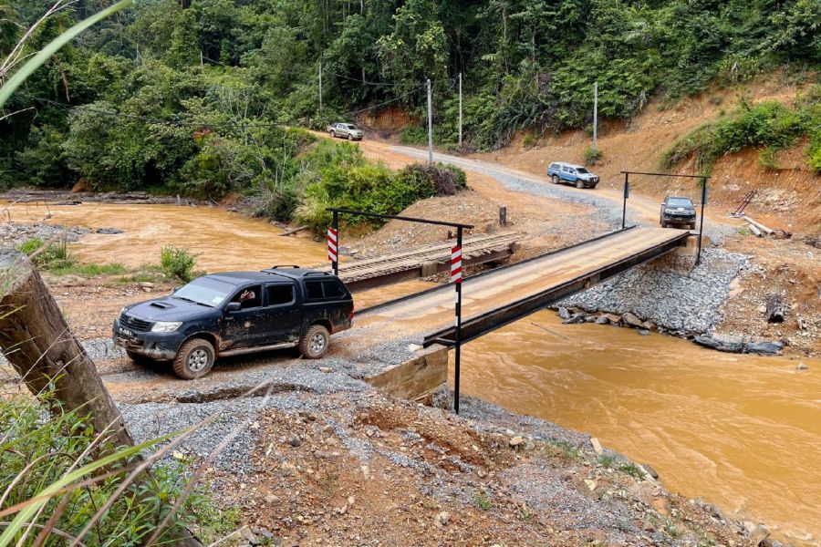 GUA MUSANG, 9 JULY 2023 - A vehicle crossing the Sungai Perias using a bridge which will be upgraded to a steel bridge to connect to the Orang Asli settlement in Pos Gob. -BERNAMA Pic