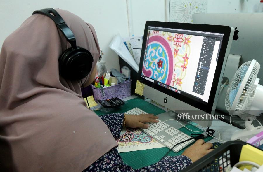 A graphic artist working on the scanned copy of a ‘zukhruf’
