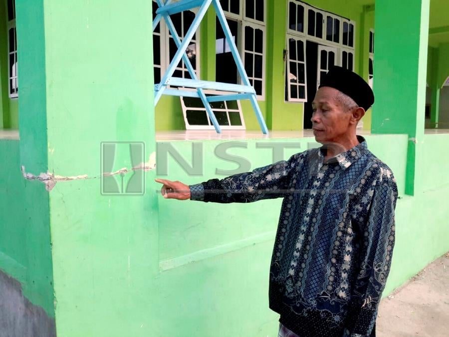 Caretaker of Masjid Jaam’i, Desa Tolase, Anwar showing the cracked pillar, among the damages suffered by the buildin. NSTP/MOHD JAMILUL ANBIA MD DENIN